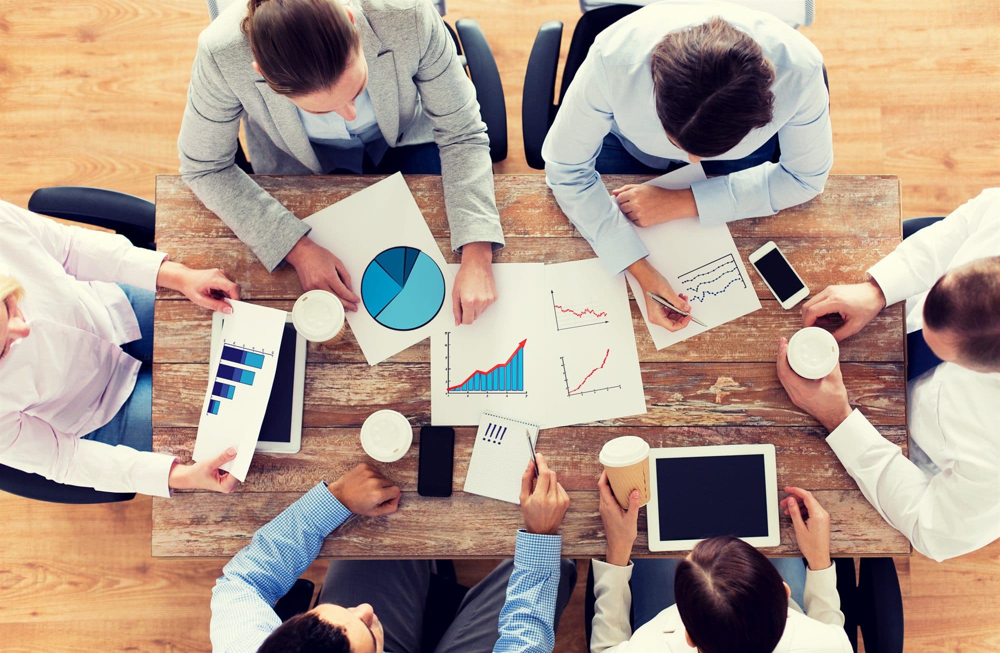 Leadership team reviewing distributor performance charts around a conference table