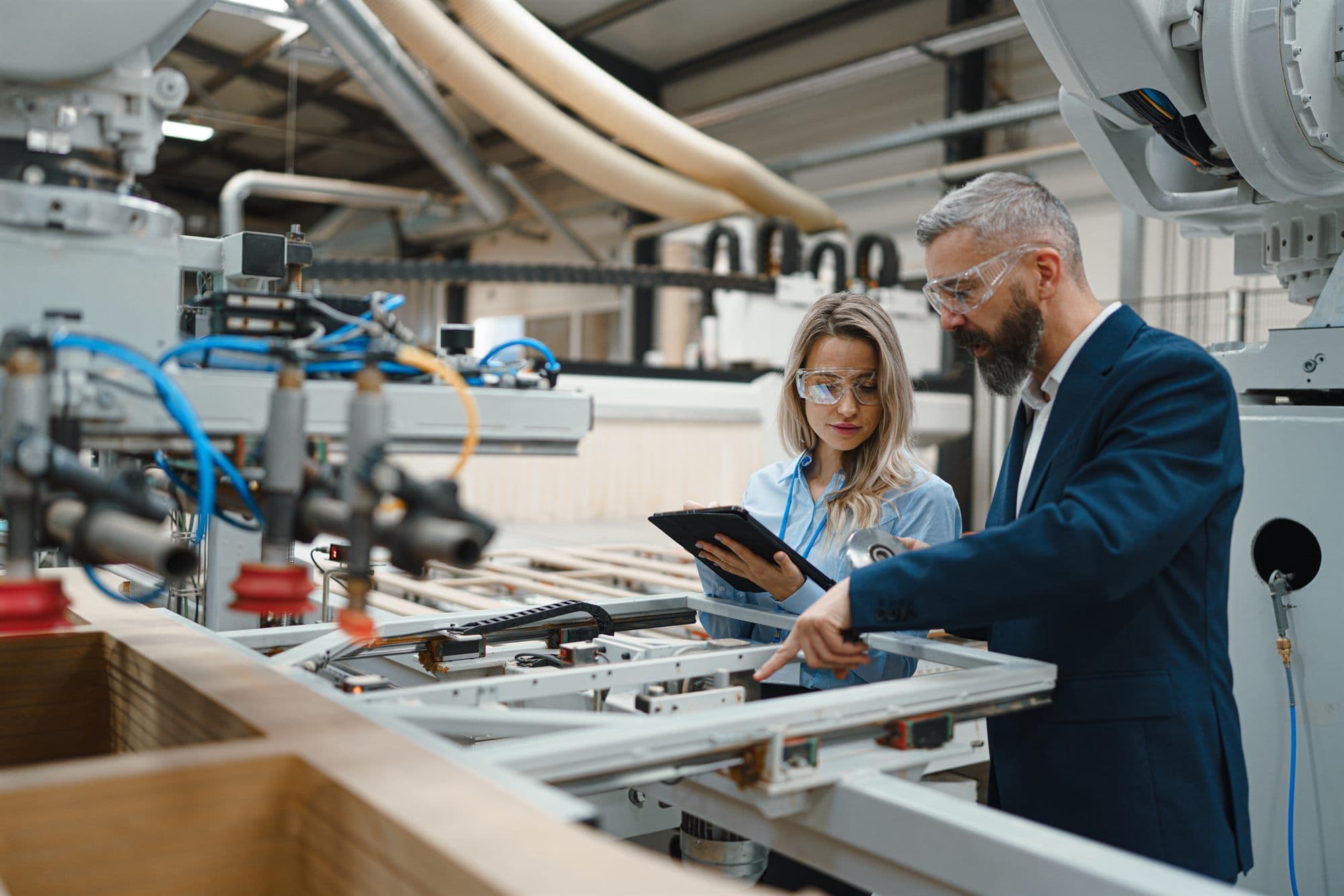 Manufacturer and partner reviewing automated machinery together on a plant floor