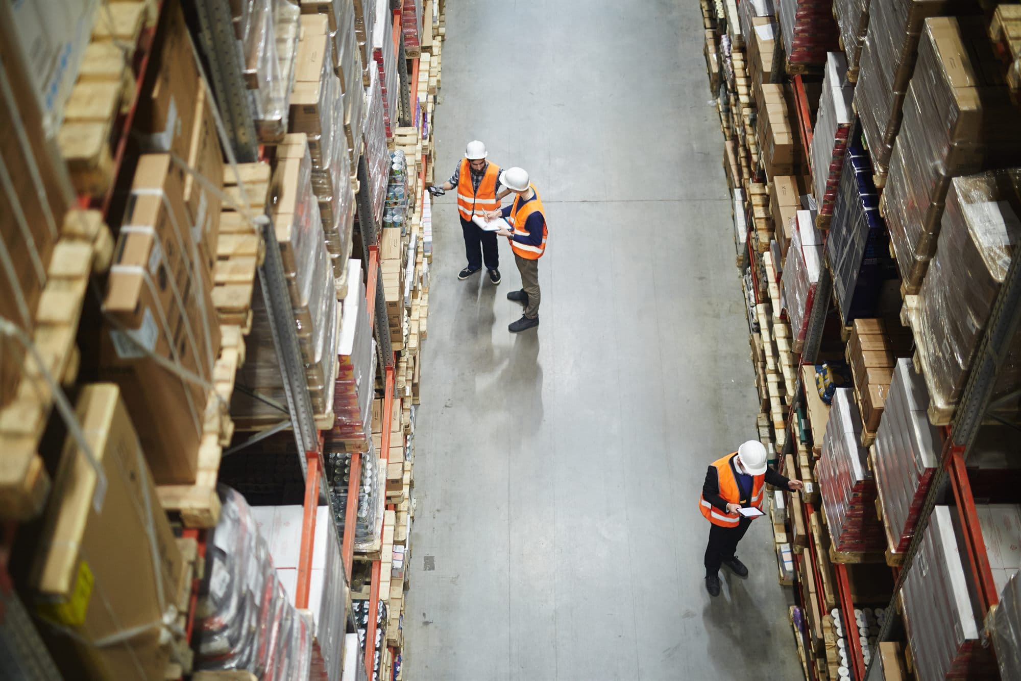 Warehouse team checking inventory along a distribution aisle